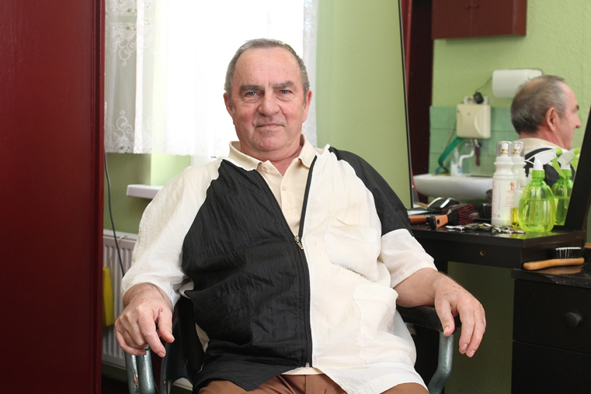 Tadeusz Kaszuba w historycznym fotelu w swoim zakładzie