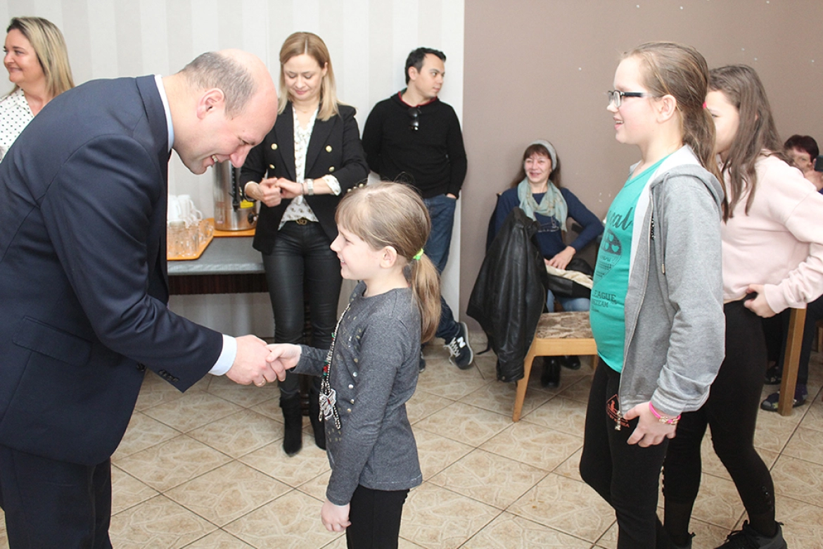 Wiceminister Szymon Szynkowski vel Sęk podczas spotkania z repatriantami wręczył dzieciom plecami